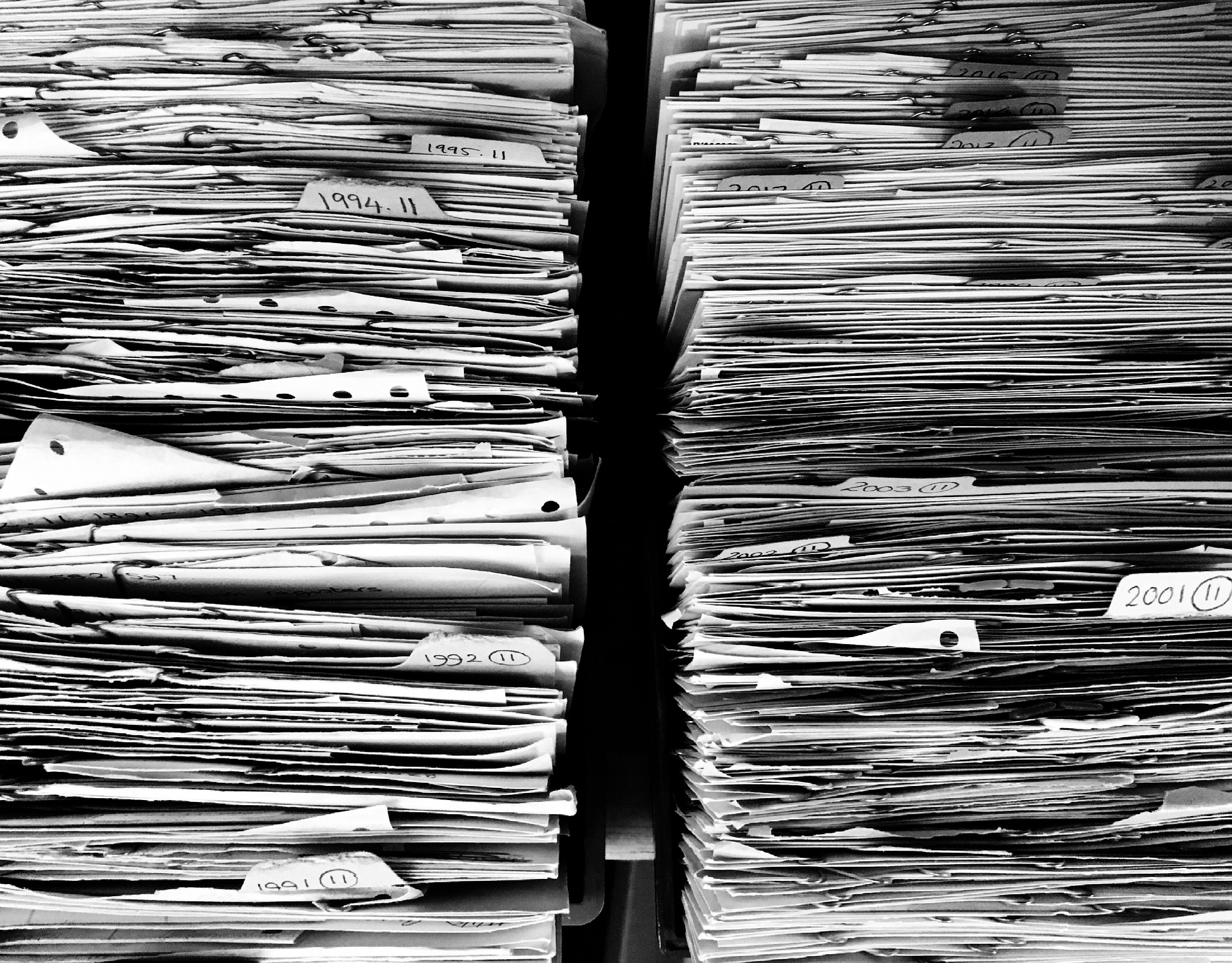 Two stacks of paper files next to each other in black and white